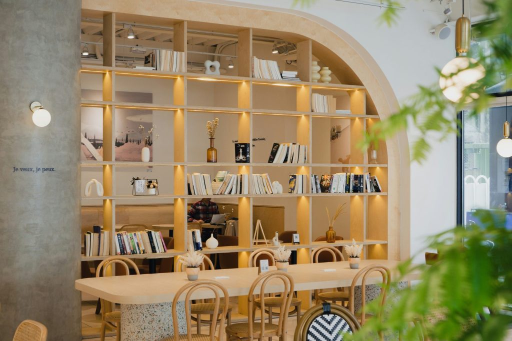 Un café décoré sur le thème de la bibliothèque, avec des étagères en bois.